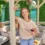 Woman enjoying wine in a custom garden structure design featuring comfortable seating and decorative elements.